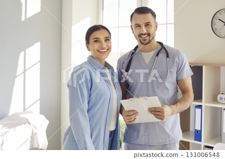 Portrait of a happy smiling young woman together with her male doctor at the clinic Portrait of a happy smiling young woman together with her male doctor at the clinic 131006548