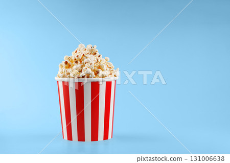 Classic red striped popcorn cardboard cup on blue background Classic red striped popcorn cardboard cup on blue background 131006638