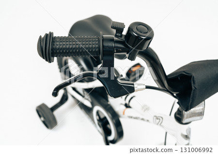 Detail shot of black handlebar grip and brake system of kids bike. Great for e-commerce, product manuals, bicycle design and safety advertising Detail shot of black handlebar grip and brake system of kids bike. Great for e-commerce, product manuals, bicycle design and safety advertising 131006992