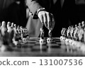 Elegant black and white close up of hand making strategic chess move in classic setting 131007536