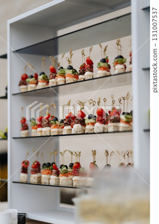 Elegant gourmet appetizers on skewers served at a luxury wedding or banquet reception 131007537