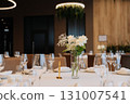 Elegant wedding table setup with white flowers and modern lighting in luxury restaurant 131007541