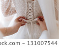 Bridal dress back lacing close up on wedding morning preparation moment 131007544