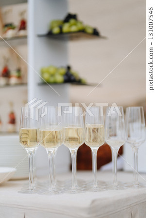 Elegant champagne glasses ready for celebration at luxury outdoor event Elegant champagne glasses ready for celebration at luxury outdoor event 131007546