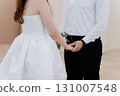 Bride and groom holding hands during intimate wedding ceremony in minimalist setting 131007548