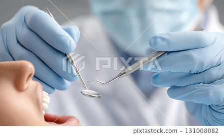 Dentist treats patient during dental exam with tools in hands 131008082