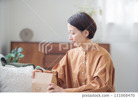 A Japanese woman in her 40s holding an item purchased online 131008470