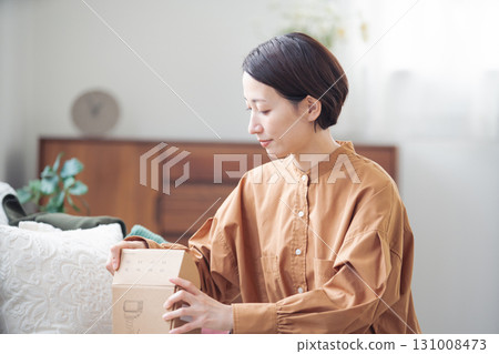 A Japanese woman in her 40s holding an item purchased online A Japanese woman in her 40s holding an item purchased online 131008473