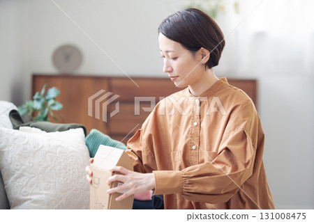 A Japanese woman in her 40s holding an item purchased online 131008475