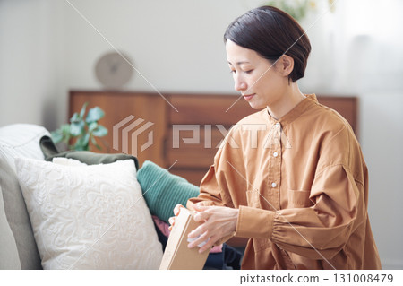 A Japanese woman in her 40s holding an item purchased online 131008479
