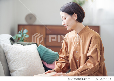 A Japanese woman in her 40s holding an item purchased online 131008483