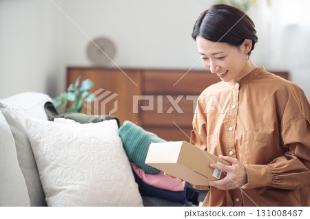 A Japanese woman in her 40s holding an item purchased online 131008487