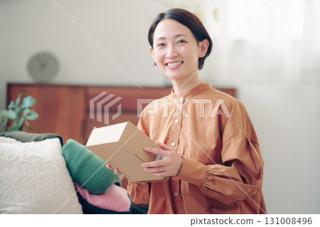 A Japanese woman in her 40s holding an item purchased online 131008496
