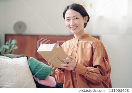 A Japanese woman in her 40s holding an item purchased online A Japanese woman in her 40s holding an item purchased online 131008498