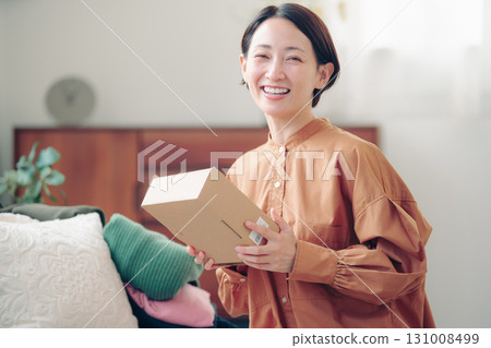 A Japanese woman in her 40s holding an item purchased online 131008499