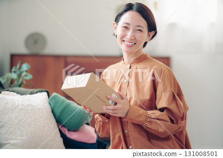 A Japanese woman in her 40s holding an item purchased online 131008501