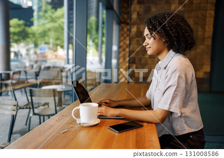 Young Professional Working in a Caf with Laptop and Coffee 131008586