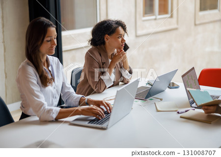 A group of diverse professionals is collaborating within a modern office work environment 131008707