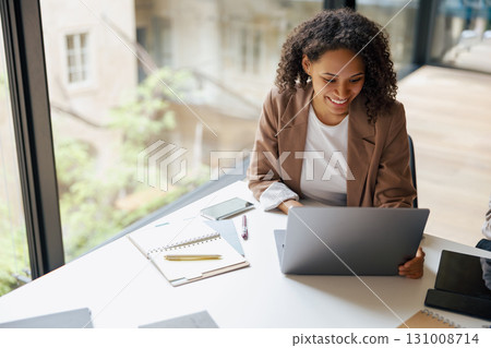 A Professional Woman Diligently Working on Her Laptop in a Contemporary Office Space A Professional Woman Diligently Working on Her Laptop in a Contemporary Office Space 131008714