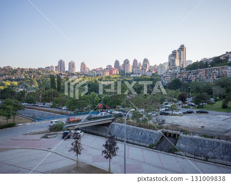 [Turkey] Cars driving on a road in the suburbs of Istanbul and skyscrapers illuminated by the setting sun in the distance 131009838
