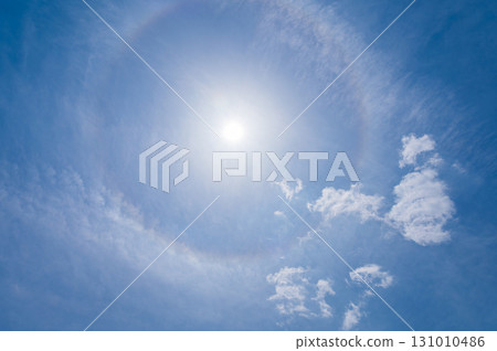 White clouds and sun halo phenomenon in the blue sky White clouds and sun halo phenomenon in the blue sky 131010486