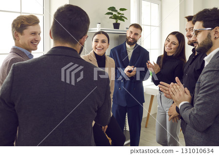 Business people applauding their successful colleague at meeting or conference 131010634