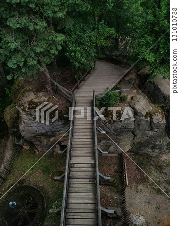 Wooden footbridge crossing scenic rock formation in kokorin, czechia 131010788