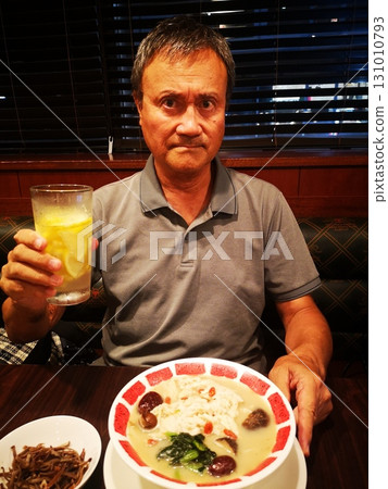 A senior man drinking lemon highball while eating steamed chicken and jujube medicinal spicy soup A senior man drinking lemon highball while eating steamed chicken and jujube medicinal spicy soup 131010793