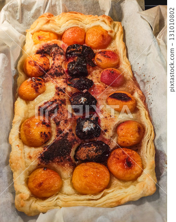 Delicious puff pastry tart with apricots, plums, and cinnamon sugar 131010802