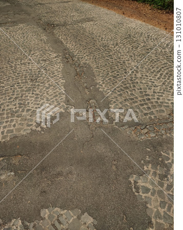 Damaged cobblestone road with asphalt filling in kokorin, czechia Damaged cobblestone road with asphalt filling in kokorin, czechia 131010807