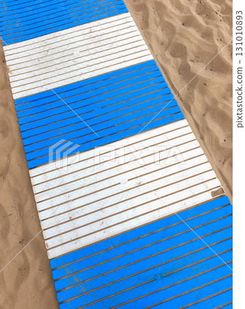Blue and white plastic walkway on the sand in lignano sabbiadoro 131010893