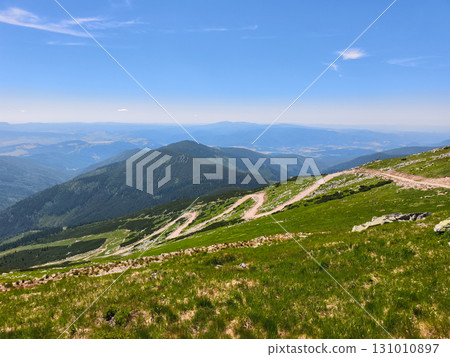 Winding mountain road traversing lush green slopes in slovakia Winding mountain road traversing lush green slopes in slovakia 131010897
