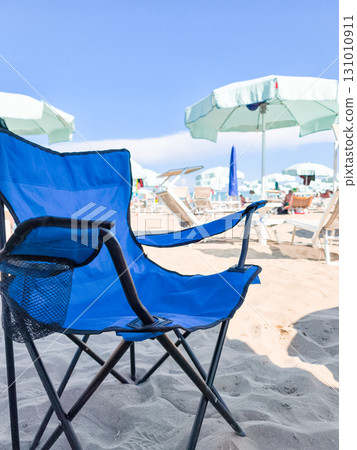 Blue beach chair enjoying summer sun on lignano sabbiadoro beach 131010911