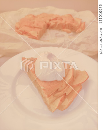 Delicious slice of apple pie with whipped cream topping on white plate for birthday 131010986