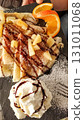 Delicious crepes with pineapple, whipped cream, chocolate topping and orange slices in slovakia strbske pleso, high tatras 131011068