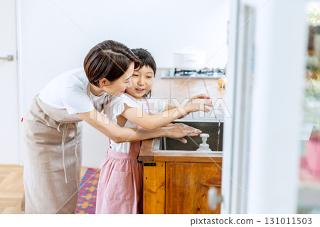 Mom washing her hands with her child 131011503