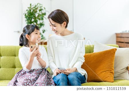 孩子媽媽看著智慧型手機 131011539