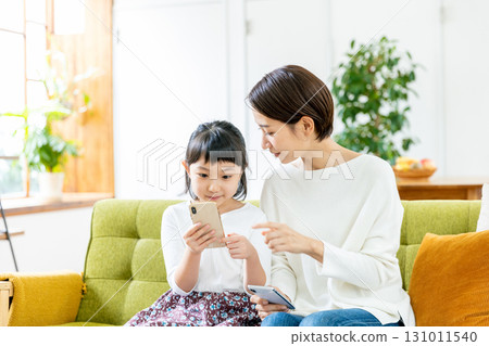 Child and mom looking at smartphone 131011540