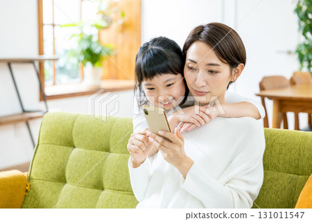 父母和孩子在智慧型手機上觀看視頻 131011547