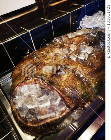 一條鮟鱇魚在一家鮟鱇魚料理餐廳的入口處休息 一條鮟鱇魚在一家鮟鱇魚料理餐廳的入口處休息 131011725