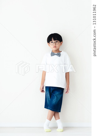 站在白牆前的小學男孩 131011962