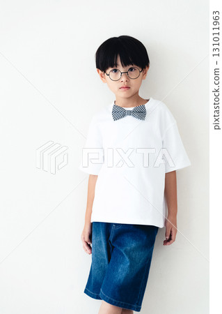 站在白牆前的小學男孩 131011963