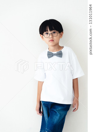 站在白牆前的小學男孩 131011964