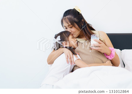 Daughter bring a glass of milk for her mother in pregnancy. 131012864