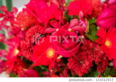 A bouquet of red rose. Beautiful bouquet of yellow - orange rose. Fresh roses in a vase decorated on the table close up. A bouquet of red rose. Beautiful bouquet of yellow - orange rose. Fresh roses in a vase decorated on the table close up. 131012913