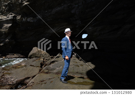 A senior Japanese man in a suit, a bereaved family member, pays tribute to the Pacific War victims in a cave on a southern island 131012980