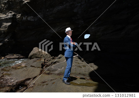 A senior Japanese man in a suit, a bereaved family member, pays tribute to the Pacific War victims in a cave on a southern island A senior Japanese man in a suit, a bereaved family member, pays tribute to the Pacific War victims in a cave on a southern island 131012981
