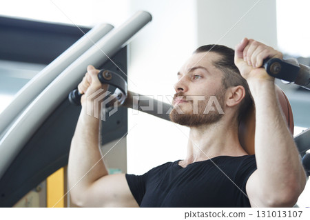 Good looking and muscular hispanic man doing a weight training exercise in the gym, a man focus a weight training at the arm and upper body. Healthy lifestyle concept. 131013107