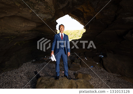 A senior Japanese man in a suit, a bereaved family member, pays tribute to the Pacific War victims in a cave on a southern island A senior Japanese man in a suit, a bereaved family member, pays tribute to the Pacific War victims in a cave on a southern island 131013126