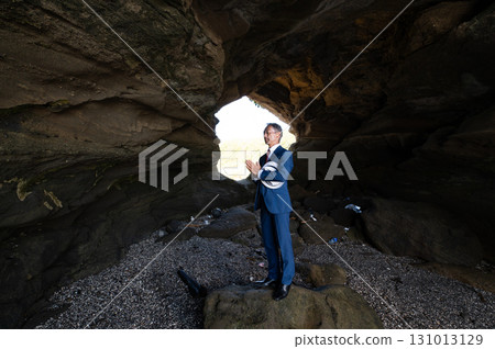 A senior Japanese man in a suit, a bereaved family member, pays tribute to the Pacific War victims in a cave on a southern island A senior Japanese man in a suit, a bereaved family member, pays tribute to the Pacific War victims in a cave on a southern island 131013129